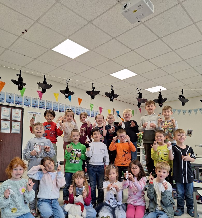 Children show off their Halloween surprise: a lollipop dressed as a ghost and a spider ring