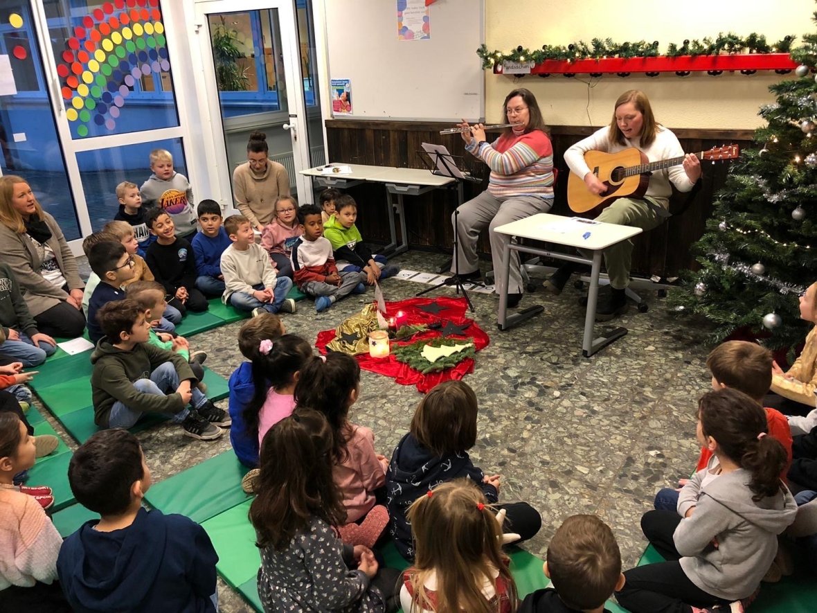 Dos mujeres tocan instrumentos y los niños cantan - Link öffnet seitenüberlagerndes Dialog-Fenster