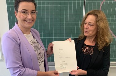 La Sra. Harbig entrega el certificado a la Sra. Bronikhoff.