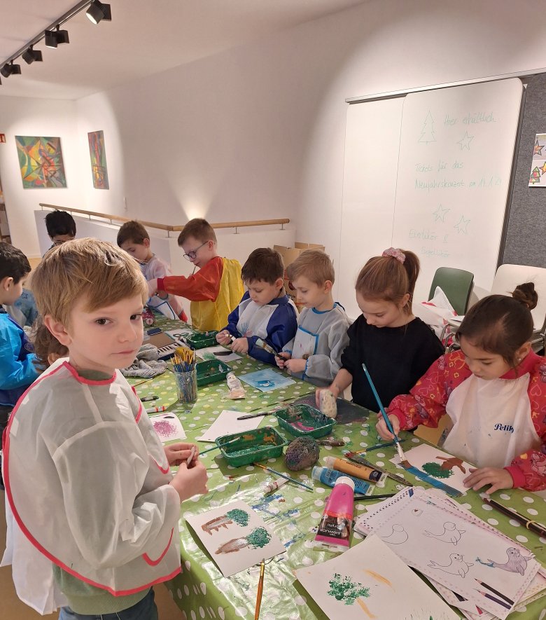Les enfants peignent avec des pinceaux et de la peinture