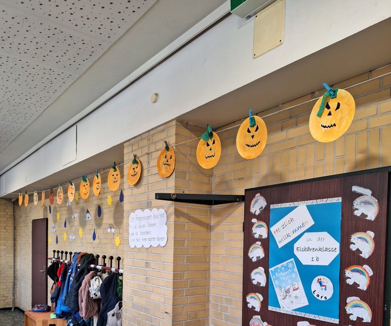 Visages de citrouilles bricolés suspendus à une corde dans le couloir de l'école, décoration d'Halloween