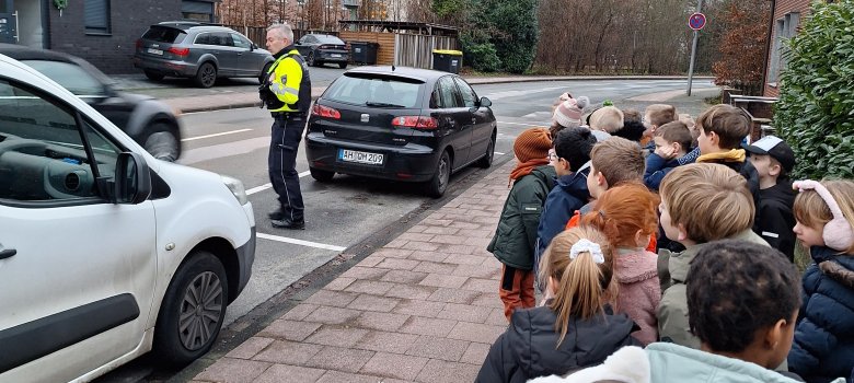 Un policier explique aux enfants comment traverser correctement la rue