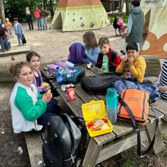 I bambini fanno colazione sulla panchina da picnic