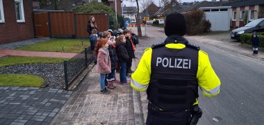 L'agente di polizia spiega ai bambini come attraversare la strada correttamente