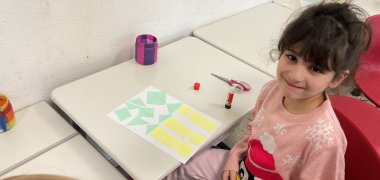 Een meisje knutselt met geometrische vormen