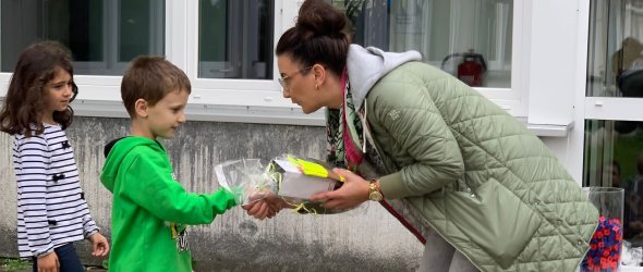 'Directoarea îi prezintă unui băiat premiul său